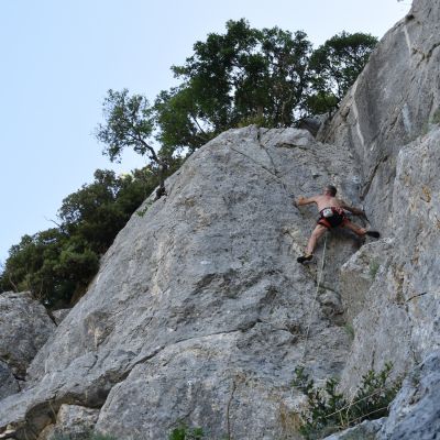 Uomo che arrampica su una falesia